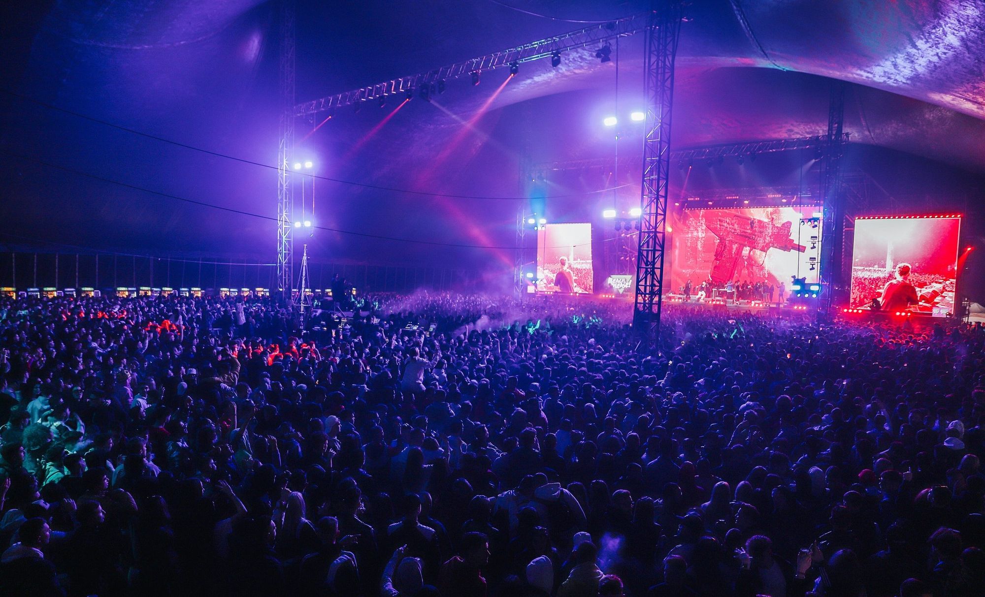 Palco de um festival com ecrãs LED e o público em frente